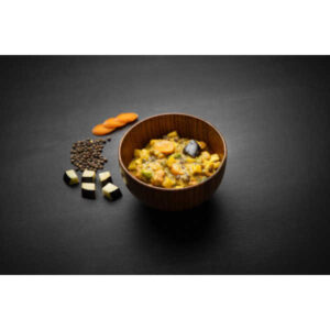 Wooden bowl of vegetable stew with carrots and eggplant, next to raw lentils, carrot slices, and eggplant cubes